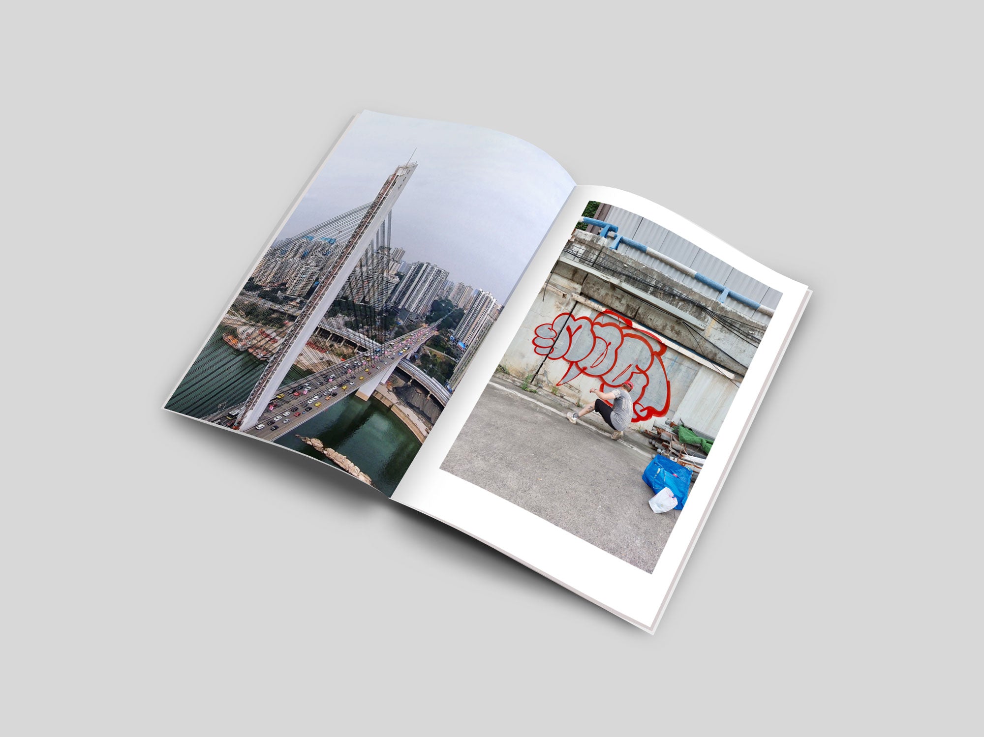 Urban photography in an open magazine, displaying a Chongqing bridge and a street artist painting graffiti.