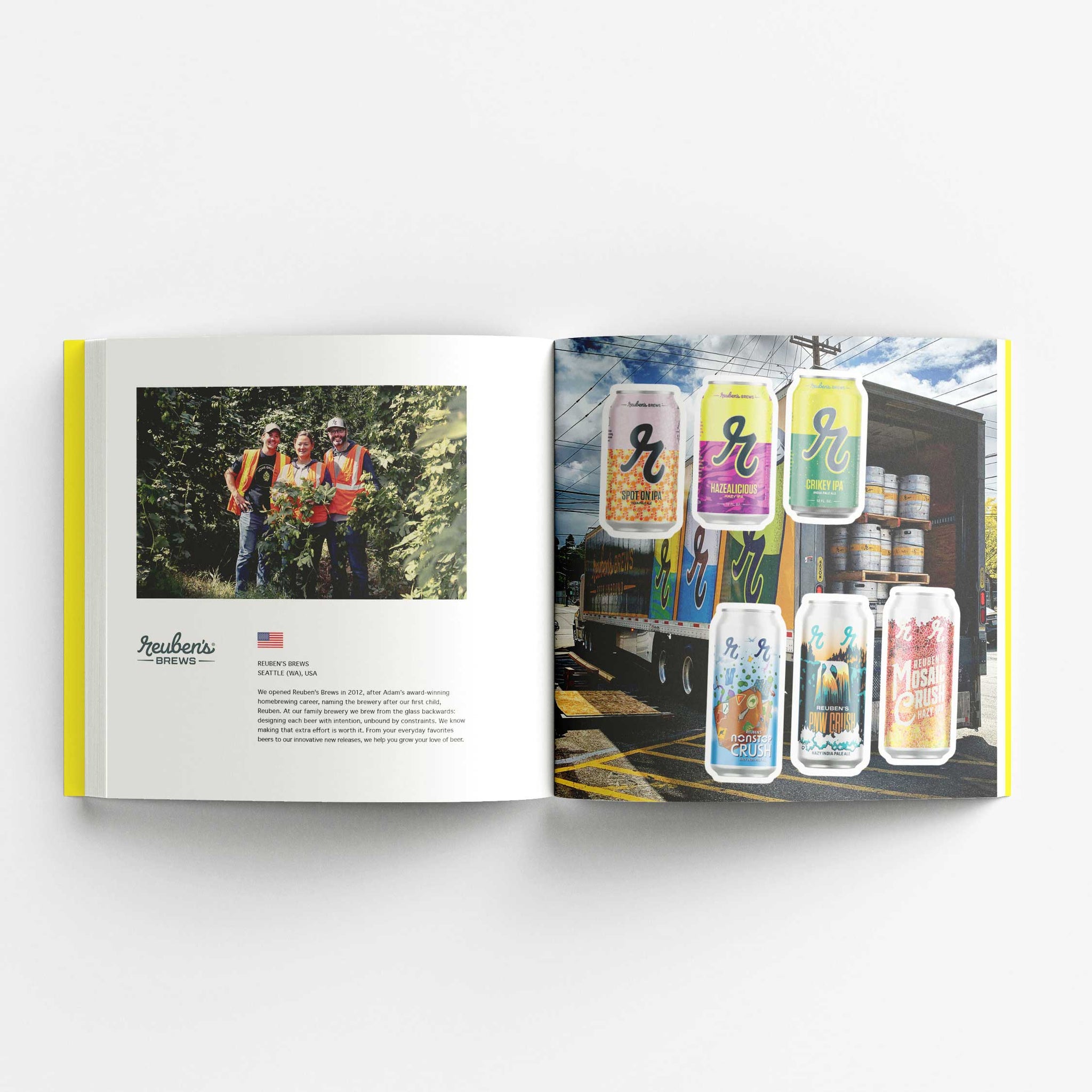 An open book displaying a two-page spread. The left page features a photo of three people wearing safety vests and standing in a hop field, accompanied by text about Reuben's Brews from Seattle, USA. The right page showcases various Reuben's Brews beer cans with colorful designs set against the background of a truck filled with beer kegs. The cans have vibrant labels featuring different flavors and styles.
