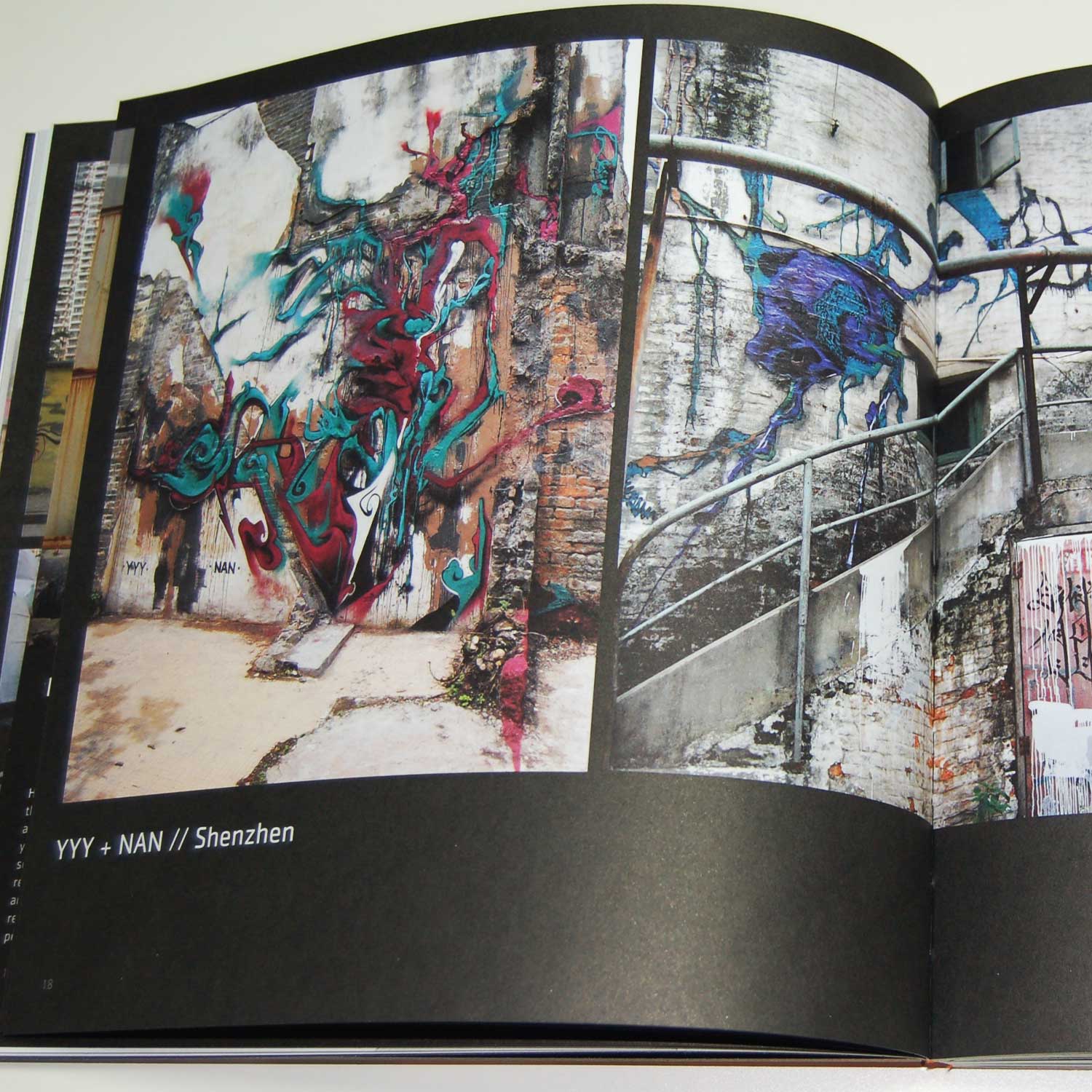 Open book from 'Graffiti Asia' showing two pages with photos of graffiti in Shenzhen by YYY and NAN. The images feature vibrant, abstract graffiti art on old, textured walls and structures.